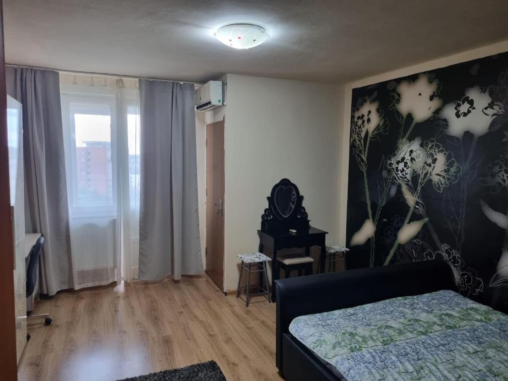 a bedroom with a bed and a painting of flowers on the wall at Oscar's Central Apartment in Timişoara