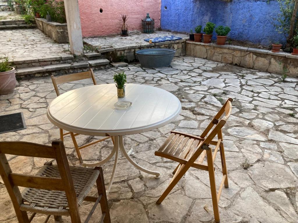 a white table and chairs on a stone patio at Kokkini Peach Budget in Kokkínion