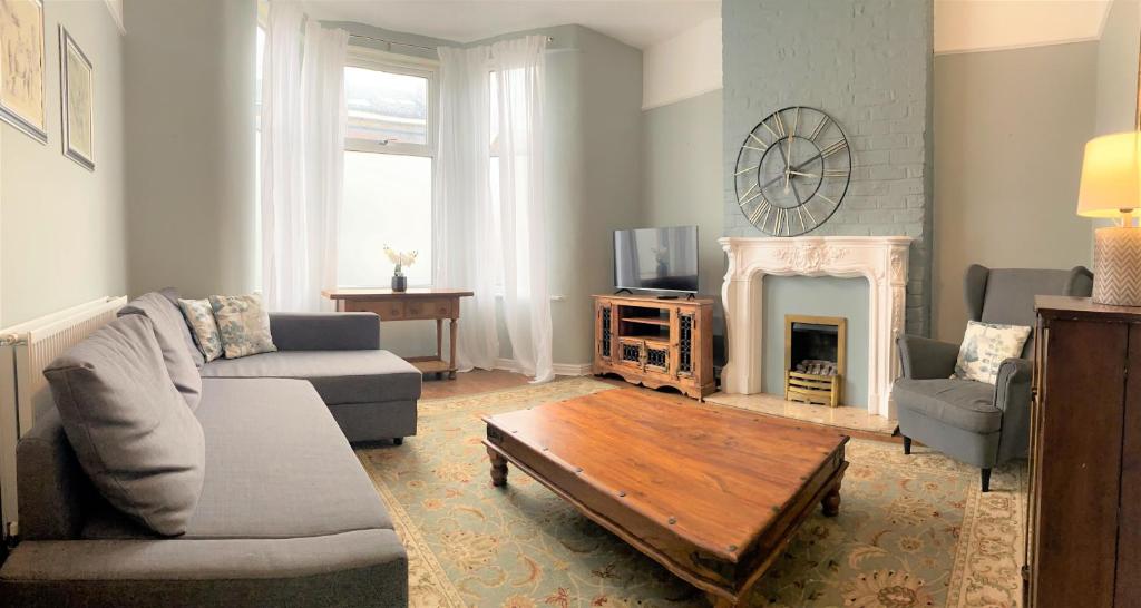 - un salon avec un canapé et une cheminée dans l'établissement Lovely Victorian House near Liverpool Centre, à Liverpool