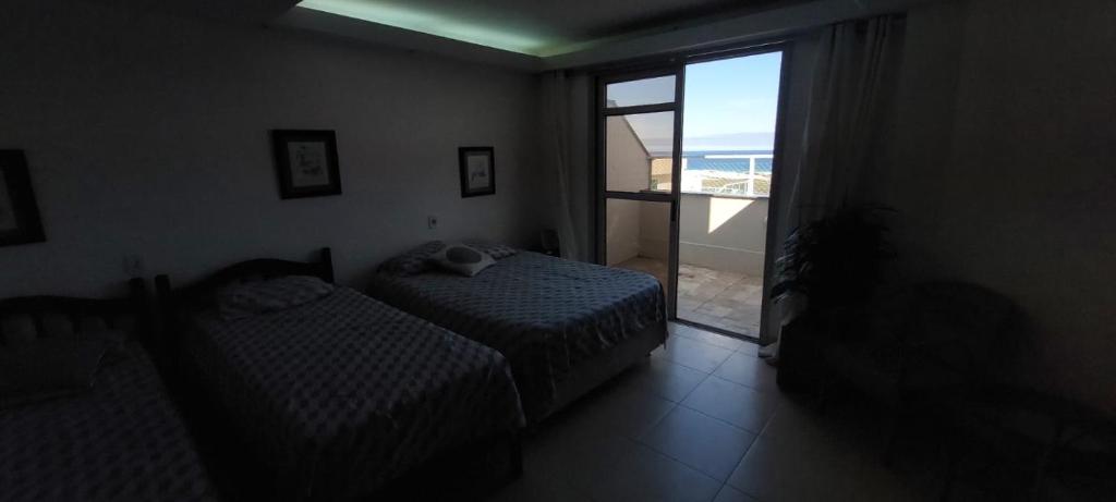 a bedroom with two beds and a view of the ocean at Triplex Cabo Frio in Cabo Frio