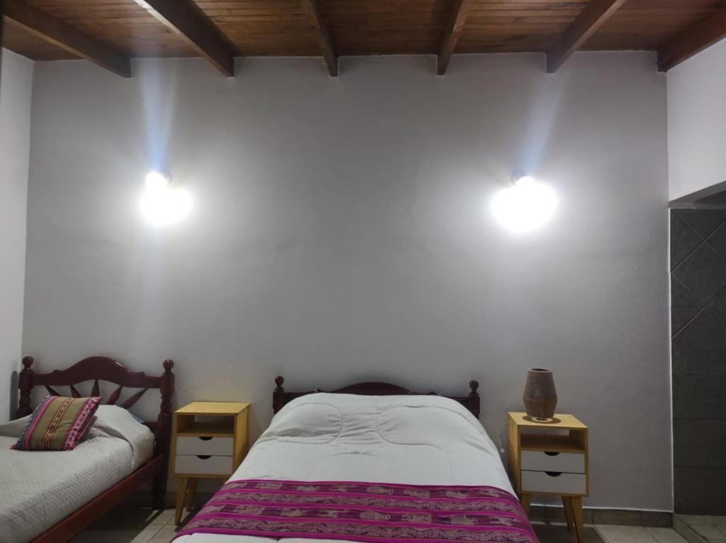 1 dormitorio con 2 camas y 2 luces en la pared en Casa Norte en Salta