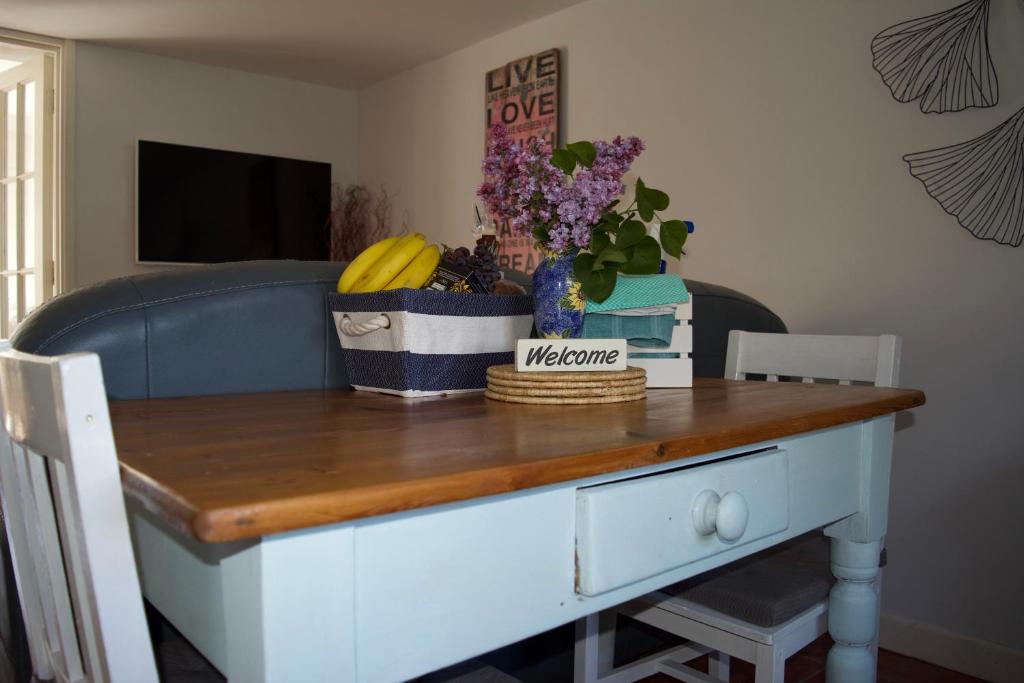 einen Tisch mit einer blauen Couch mit Bananen und Blumen in der Unterkunft Grooms in Bude