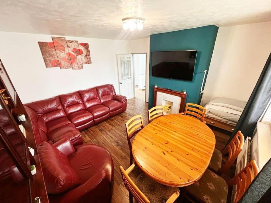 a living room with a table and a couch at Beautiful House in Bournemouth in Longham
