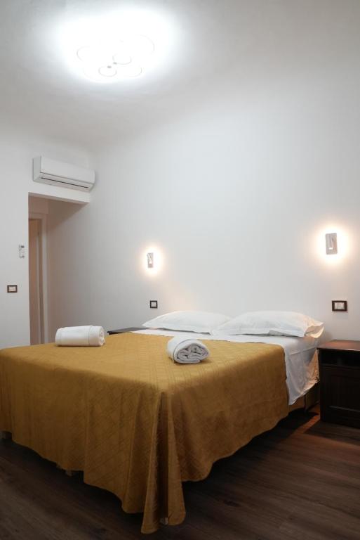 sypialnia z dużym łóżkiem i żółtym kocem w obiekcie Annetta's House we Florencji