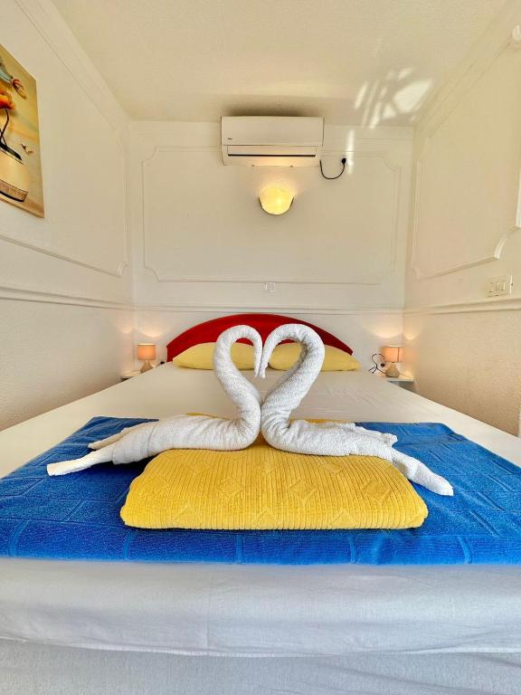 two white swans sitting on top of a bed at Montenegrina Apartment in Budva