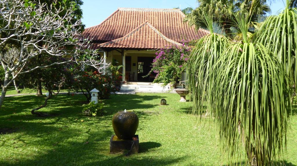 Kalibaru的住宿－Rumah Kita Villa/hotel，前面有棕榈树的房子