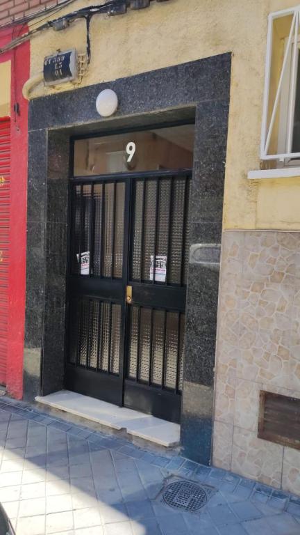 un edificio con una puerta negra con un cartel. en M&M Apartment en Madrid