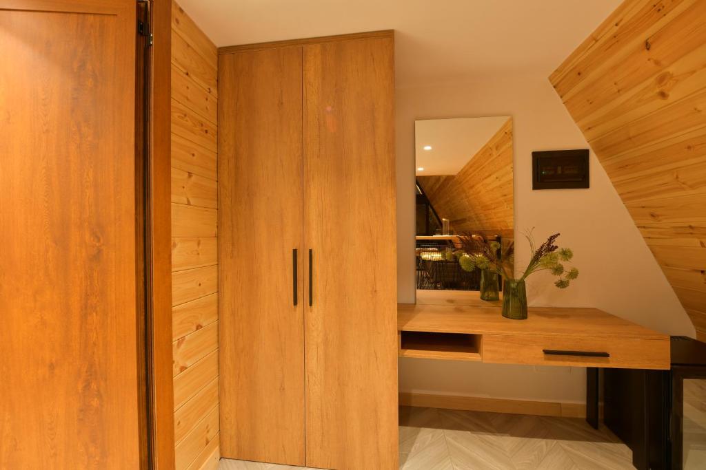 a room with a wooden cabinet and a mirror at Kompleksi Turistik DEA in Shkodër