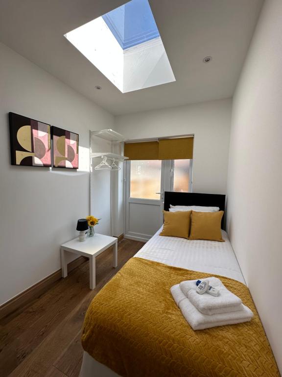 a bedroom with a large bed and a skylight at Cornwall - The Duke and Duchess in London