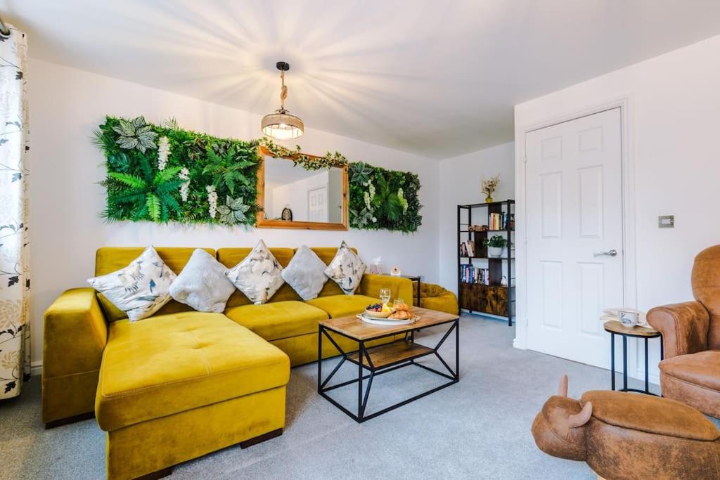 a living room with a yellow couch and a table at Luxury 3-bed house - Rothwell Gardens - 10mins from Leeds city centre in Rothwell