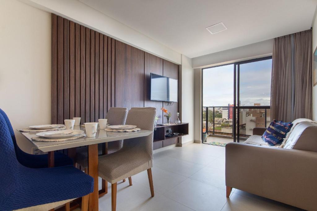 ein Esszimmer mit Tisch und Stühlen und einer Couch in der Unterkunft Park Del Prado #603 - Intermares por Carpediem in Cabedelo