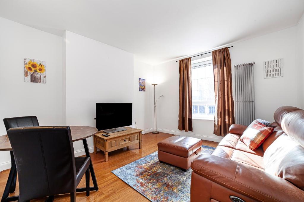 sala de estar con sofá y mesa en Comfortable 1BR flat in Canary Wharf en Londres