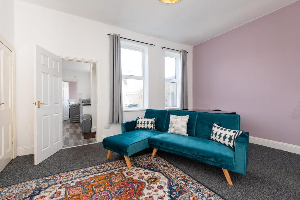 a living room with a blue couch and a rug at Rose Street in Monkwearmouth