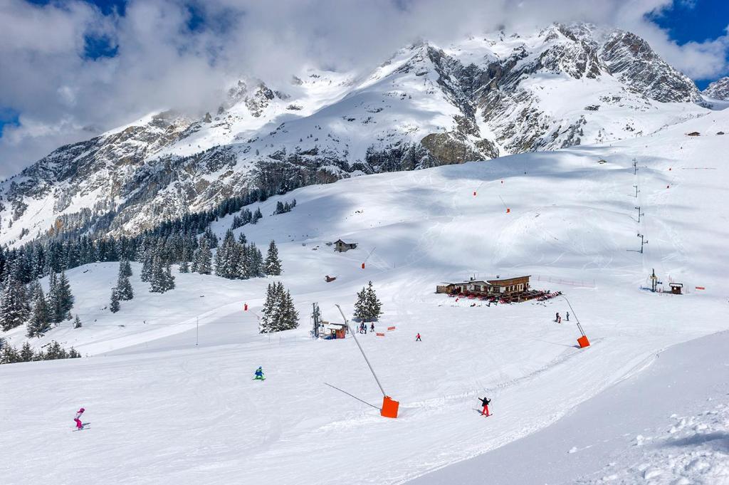 a group of people skiing down a snow covered mountain at Résidence Goélia Le Blanchot in Pralognan-la-Vanoise