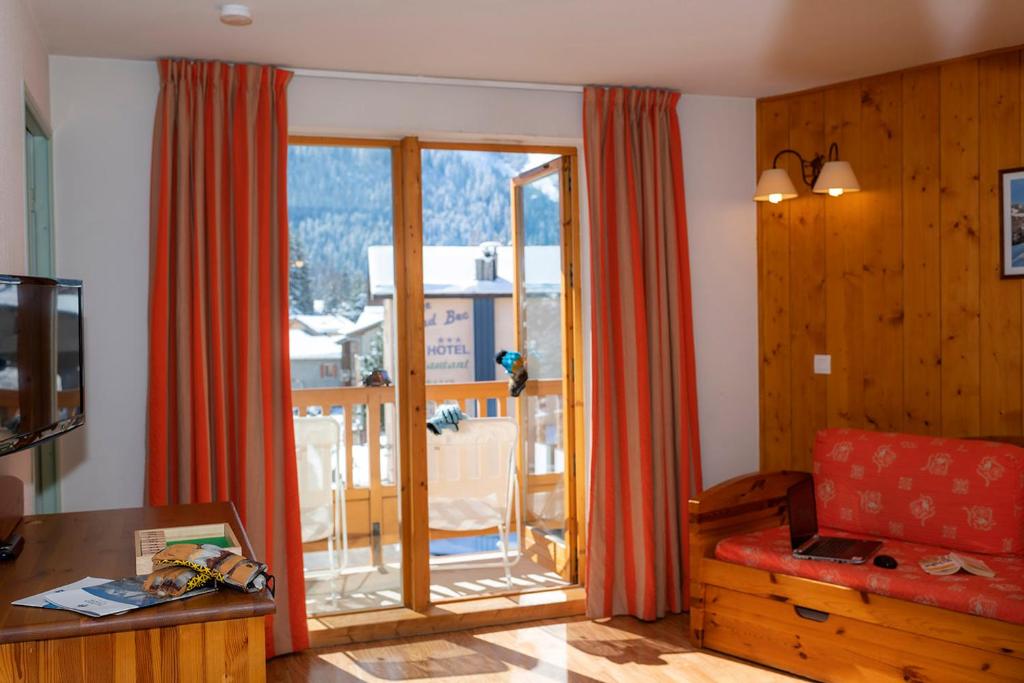 a living room with a couch and a large window at Résidence Goélia Le Blanchot in Pralognan-la-Vanoise