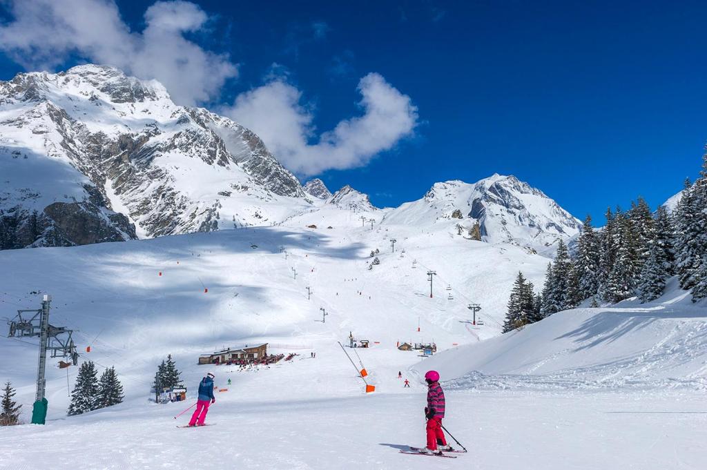 two people are skiing on a snow covered mountain at Résidence Goélia Le Blanchot in Pralognan-la-Vanoise