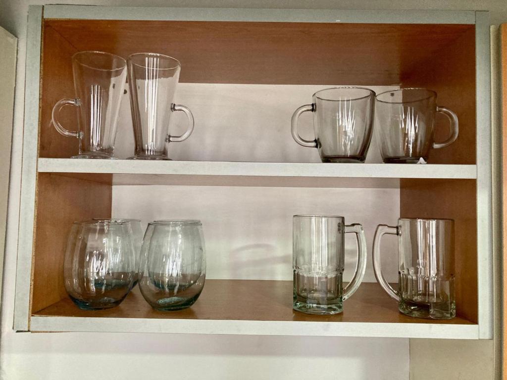 a row of glasses sitting on a shelf at 7-Exclusivo monoambiente en Moron centro in Morón