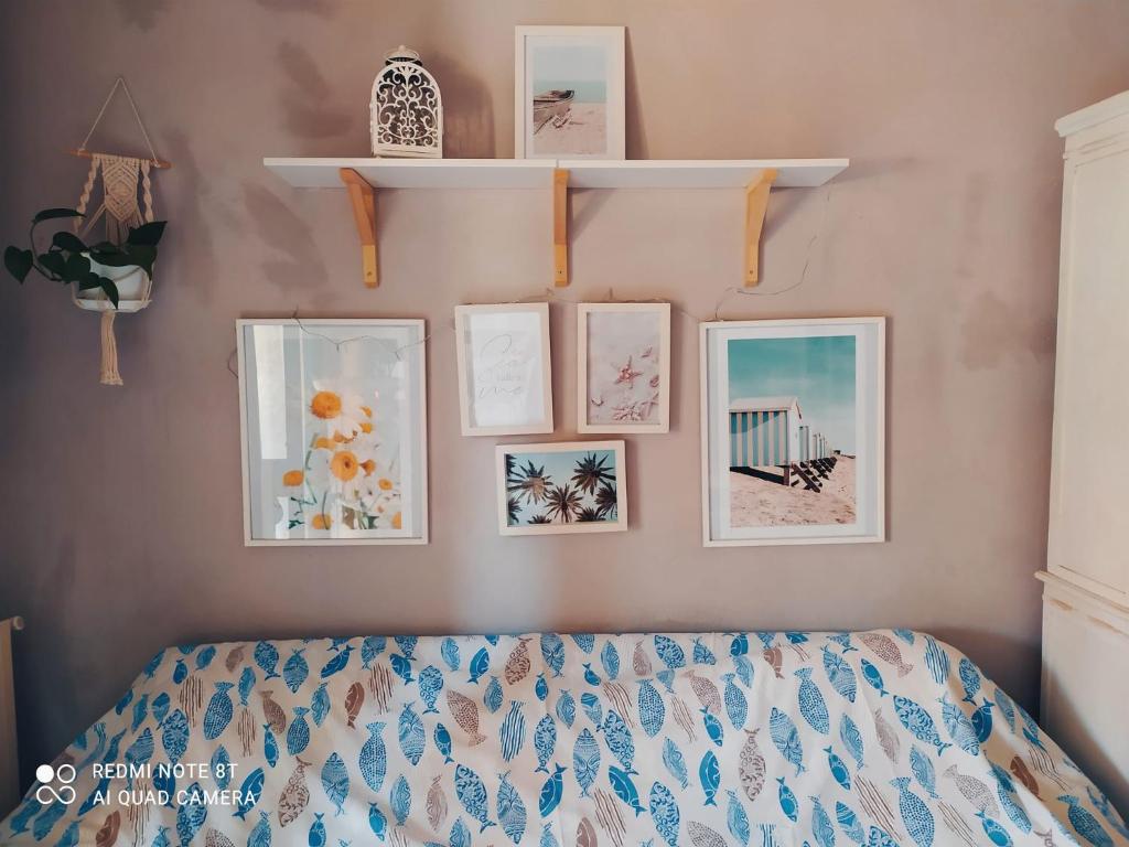 1 dormitorio con 1 cama con cuadros en la pared en lety.home appartamento incantevole vicino al mare, en Rosignano Marittimo