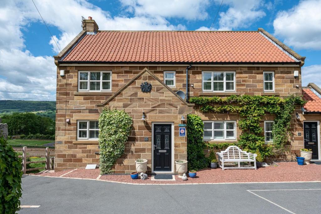 a brown brick house with a red roof at Esk View in Whitby