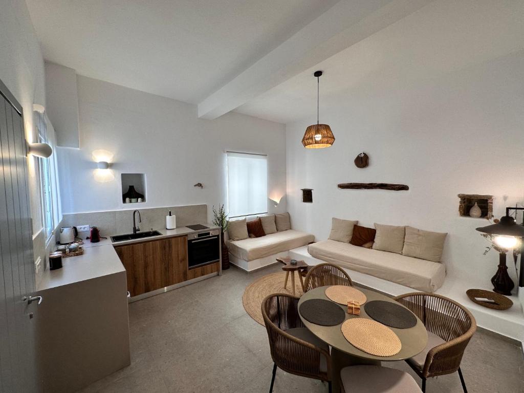 eine Küche und ein Wohnzimmer mit einem Tisch und Stühlen in der Unterkunft Koutsounos in Kythnos