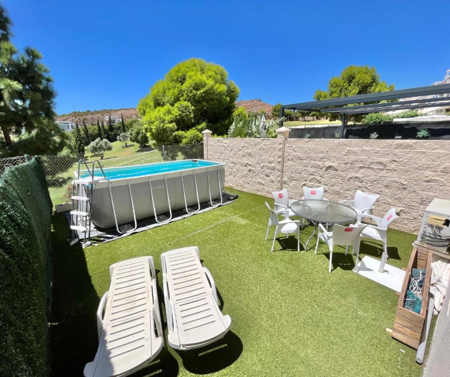 a patio with a table and chairs and a pool at Doña Julia Golf in Casares