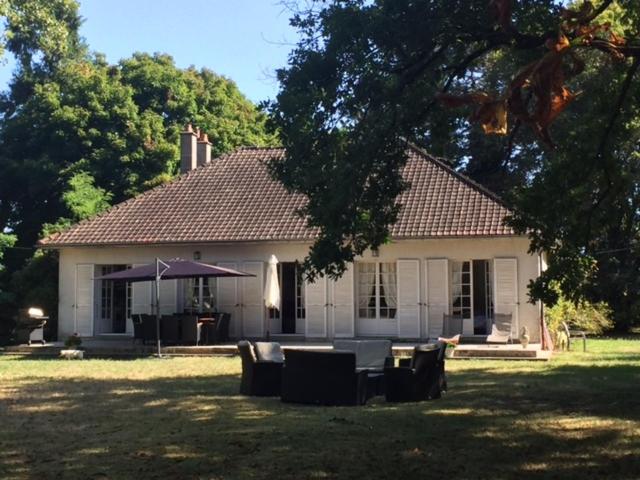 uma casa branca com uma mesa e cadeiras no quintal em La Petite Trolière em Orval