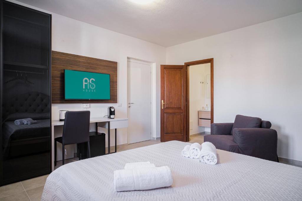 a bedroom with a bed and a desk with a tv at AS 10 HOUSE in Olbia