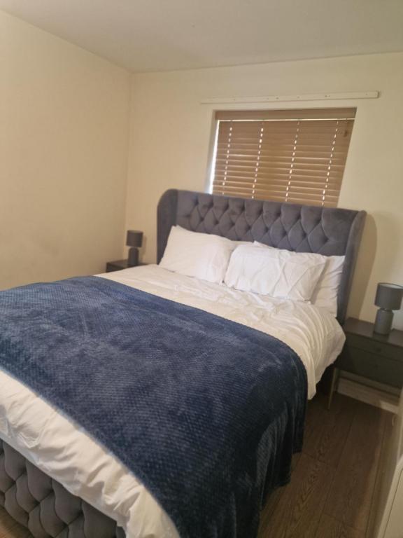 a bedroom with a large bed with a blue blanket at 2 Bed 2 Bath Ensuite - FREE secure parking in Birmingham