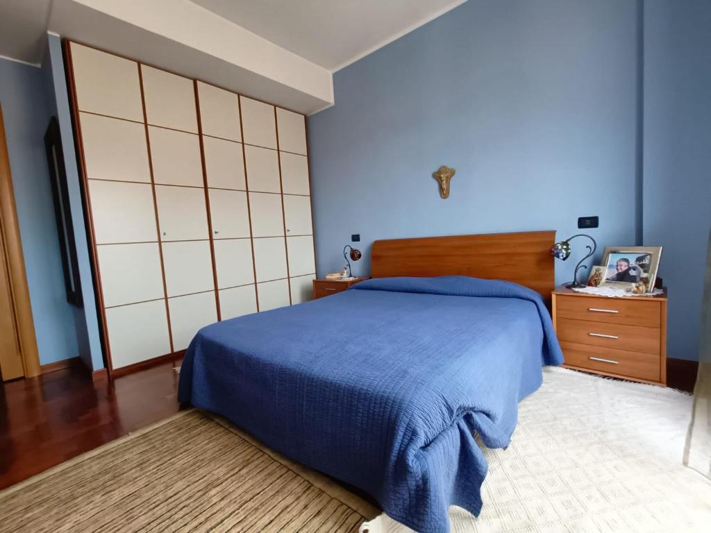 1 dormitorio con cama azul y cabecero de madera en Casa di Frank: appartamento a due passi dal mare, en Cefalú