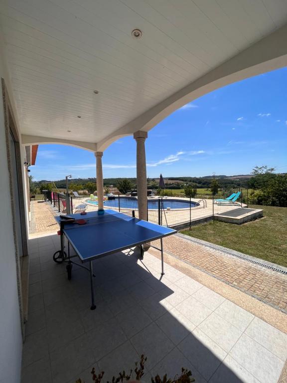 niebieski stół do ping ponga na patio z widokiem w obiekcie Villa avec piscine privée w mieście Varès