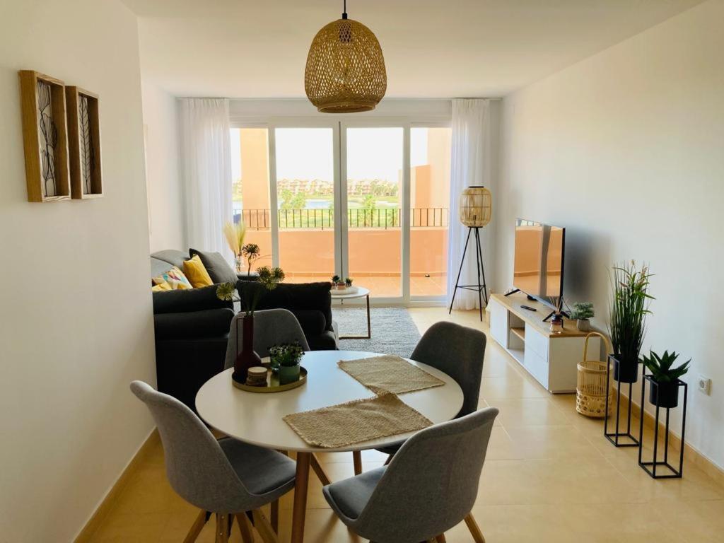 sala de estar con mesa y sillas en Zeer trendy 2-bed penthouse op de Mar Menor Golf & Padel Resort, en Torre-Pacheco