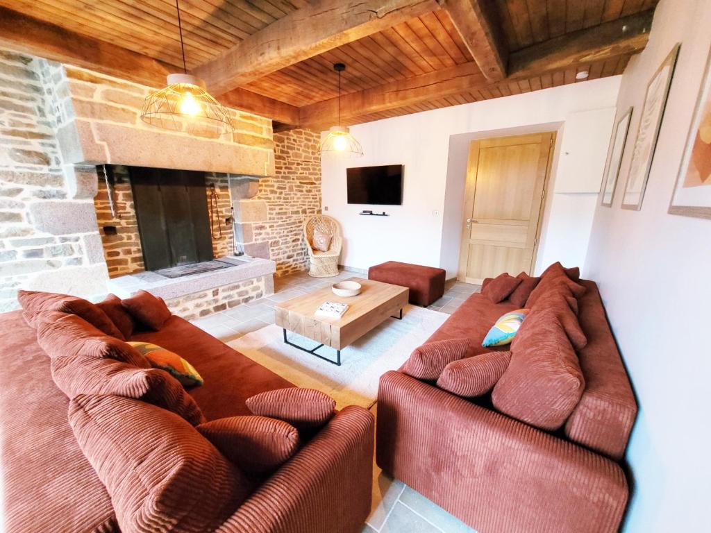 sala de estar con 2 sofás y chimenea en La Maison d'Equilly, en Équilly