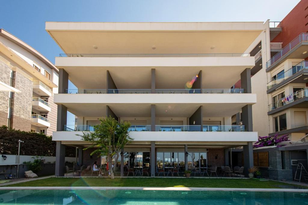 a building with a swimming pool in front of it at Hotel Vila 11 in Durrës