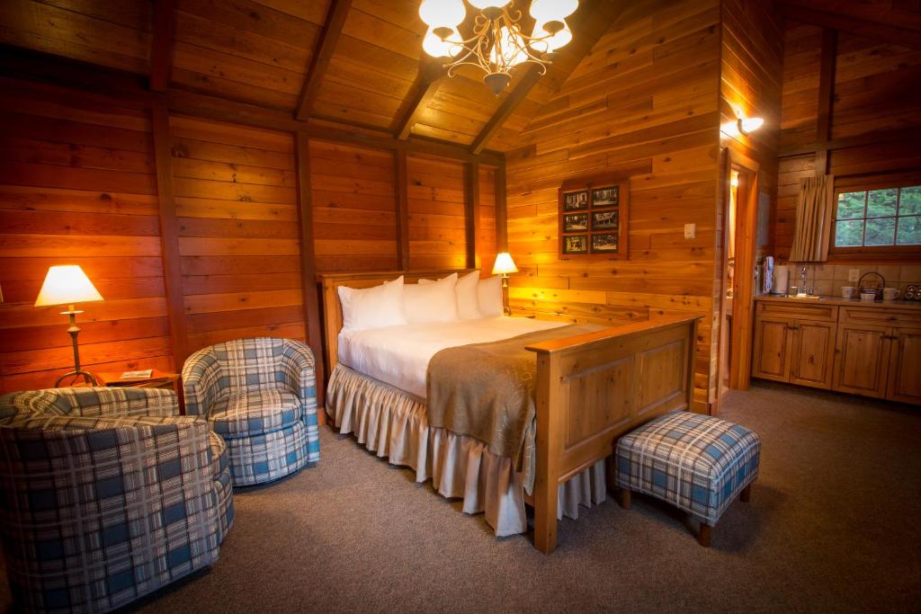 a bedroom with a bed in a wooden cabin at Paradise Lodge and Bungalows in Lake Louise