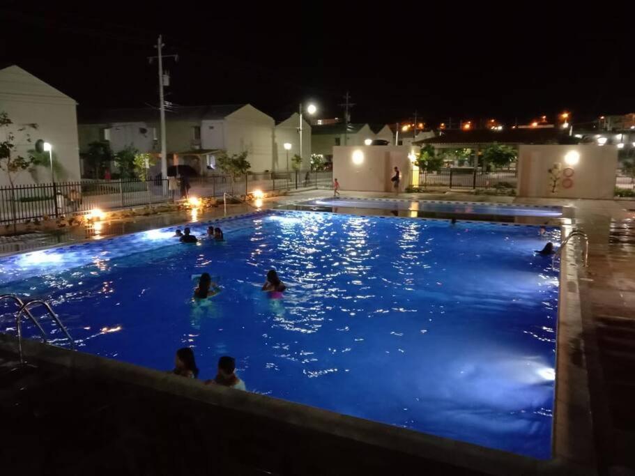 um grupo de pessoas em uma piscina à noite em Hermosa casa en Santa Marta em Santa Marta