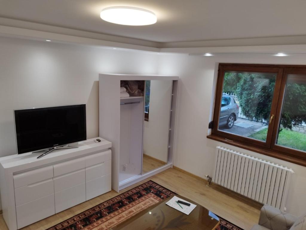 a living room with a flat screen tv on a white cabinet at Villa Amer Lux Apartments in Sarajevo