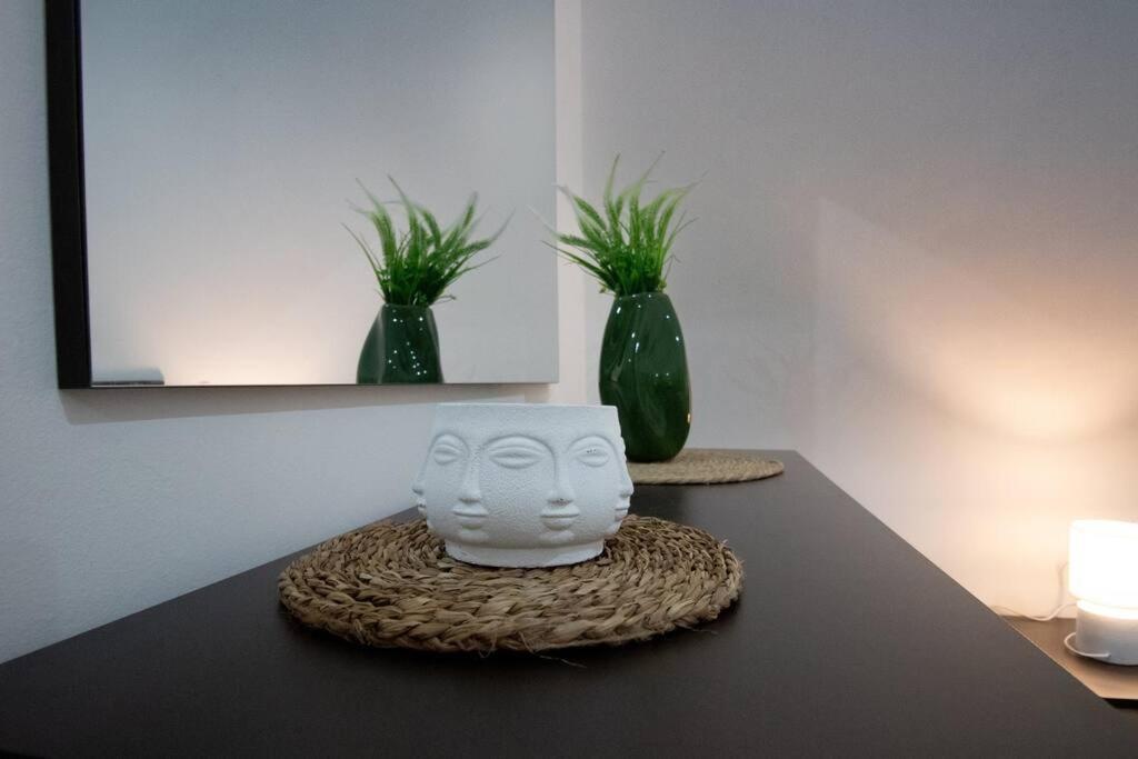 un vaso bianco seduto su un tavolo con due piante di Casa Vacanze in Salento A casa di Benedetta a Squinzano