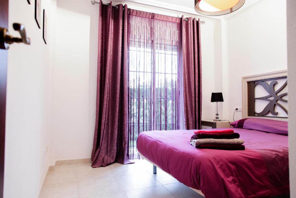 ein Schlafzimmer mit einem rosa Bett und einem Fenster in der Unterkunft Apartment Altos De La Bahia X in Torrevieja
