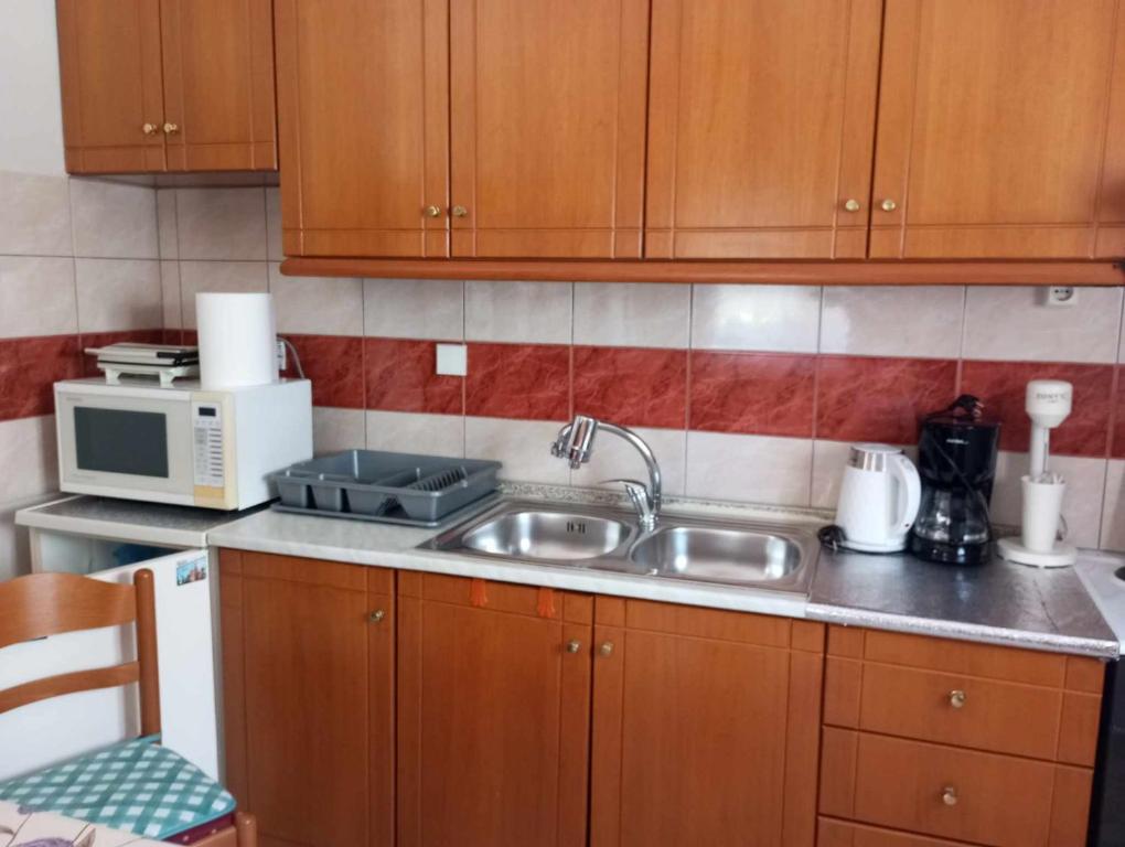 a kitchen with a sink and a microwave at Sia Beach House in Nea Karvali