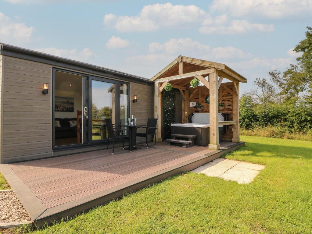 a tiny house with a deck and a gazebo at Hazel in Swadlincote