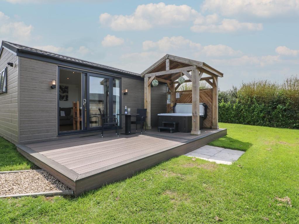 a tiny house with a deck and a pergola at Spindle in Swadlincote