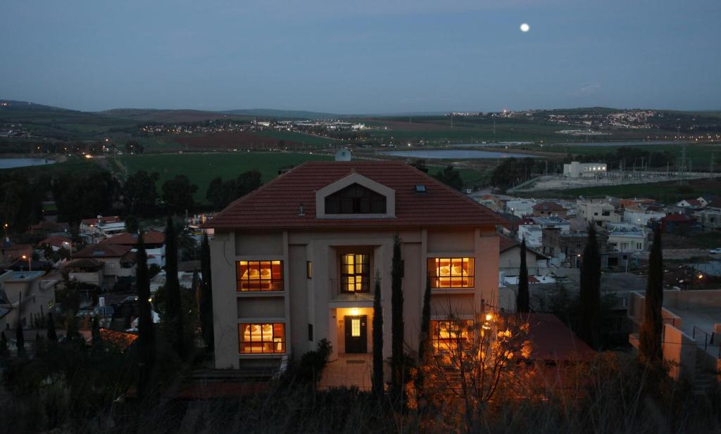 una casa con sus luces encendidas por la noche en Gilboa Guest House - Benharim en Gid‘ona