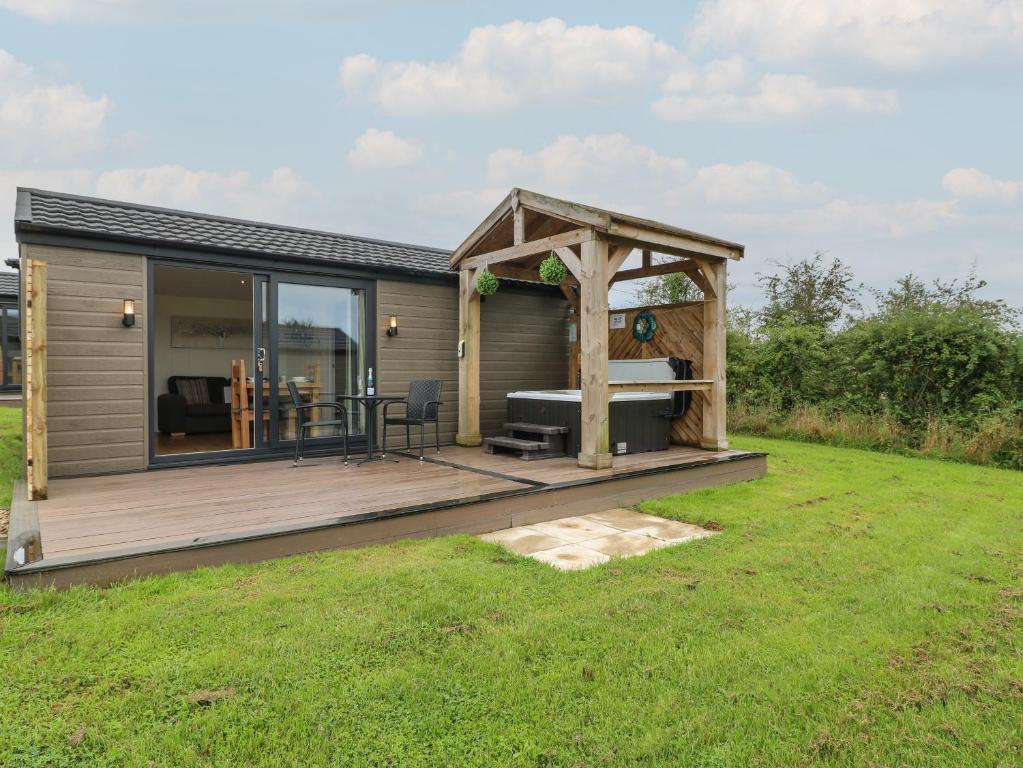 a tiny house with a deck and a gazebo at Oak in Swadlincote