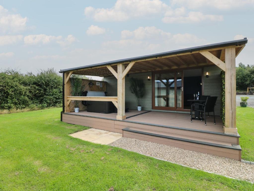 a pavilion with a deck in a yard at Juniper in Swadlincote