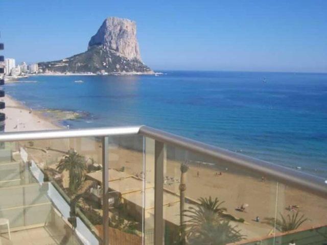 a balcony with a view of a beach and a mountain at Apartamentos Albamar II in Calpe