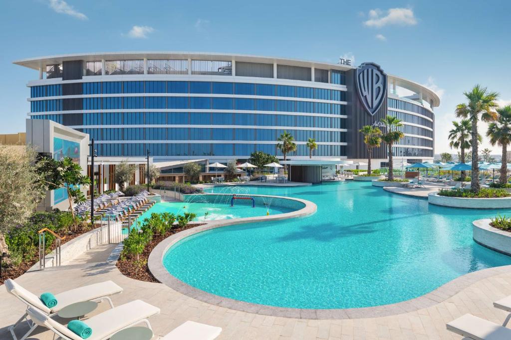 a swimming pool in front of a hotel at The WB Abu Dhabi, Curio Collection By Hilton in Abu Dhabi
