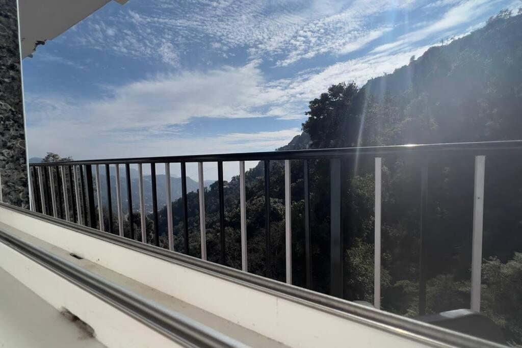 a balcony with a view of a mountain at 100 stairs holiday home in Mussoorie