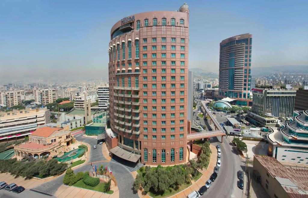 a large tall building in a city with cars at Hilton Beirut Metropolitan Palace Hotel in Beirut