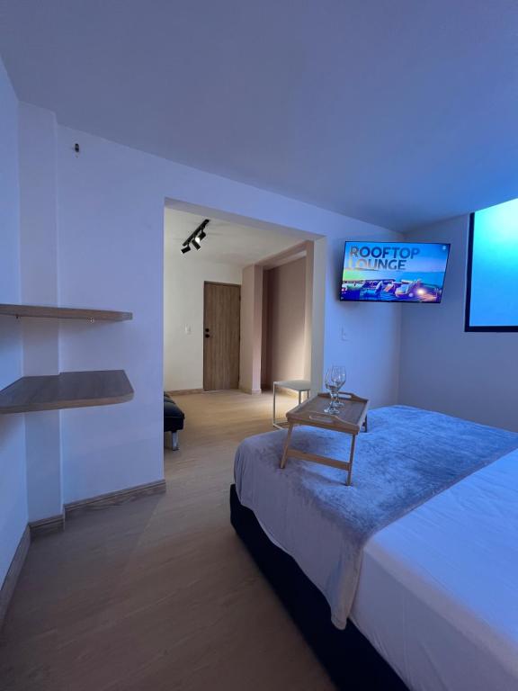 Schlafzimmer mit einem Bett und einem TV an der Wand in der Unterkunft Loft Nut con Estilo - Excelente Ubicación in Sabaneta