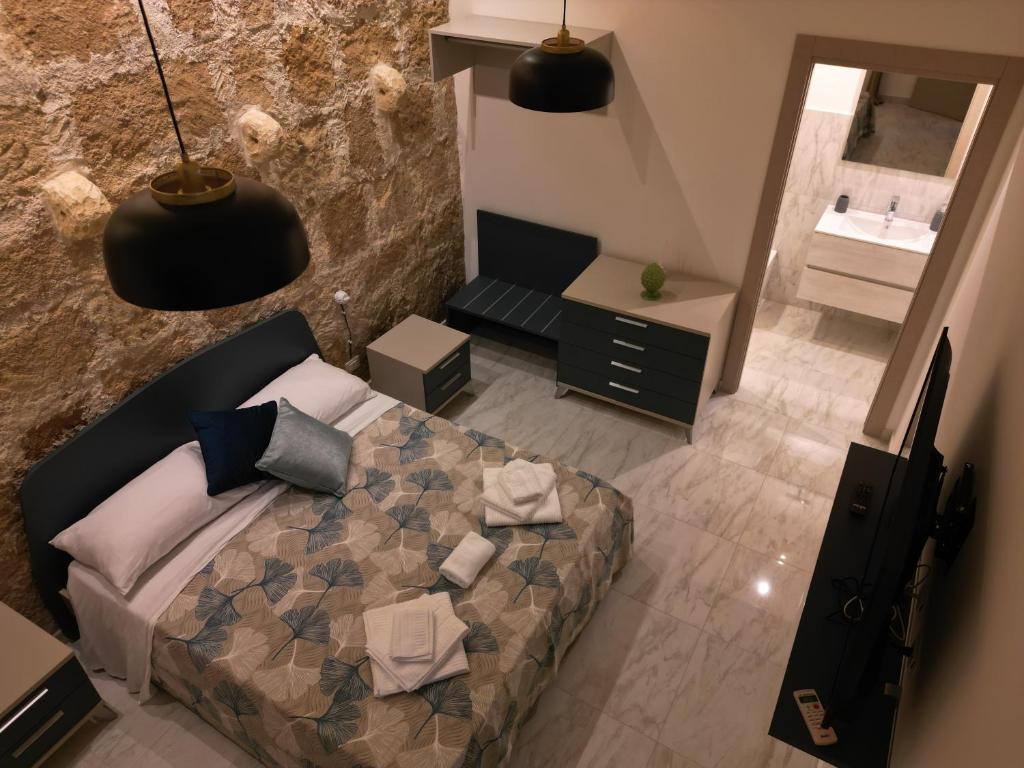 an overhead view of a bedroom with a bed and a bathroom at Lapis rooms in Pachino